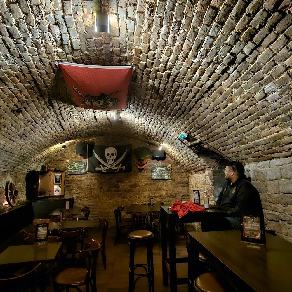 A brick vaulted pub with tables and chairs.